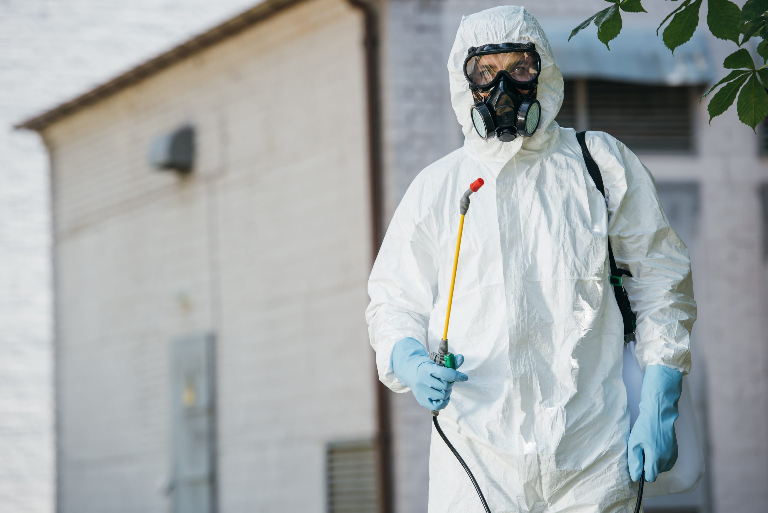 Pest control worker in protective suit with respirator